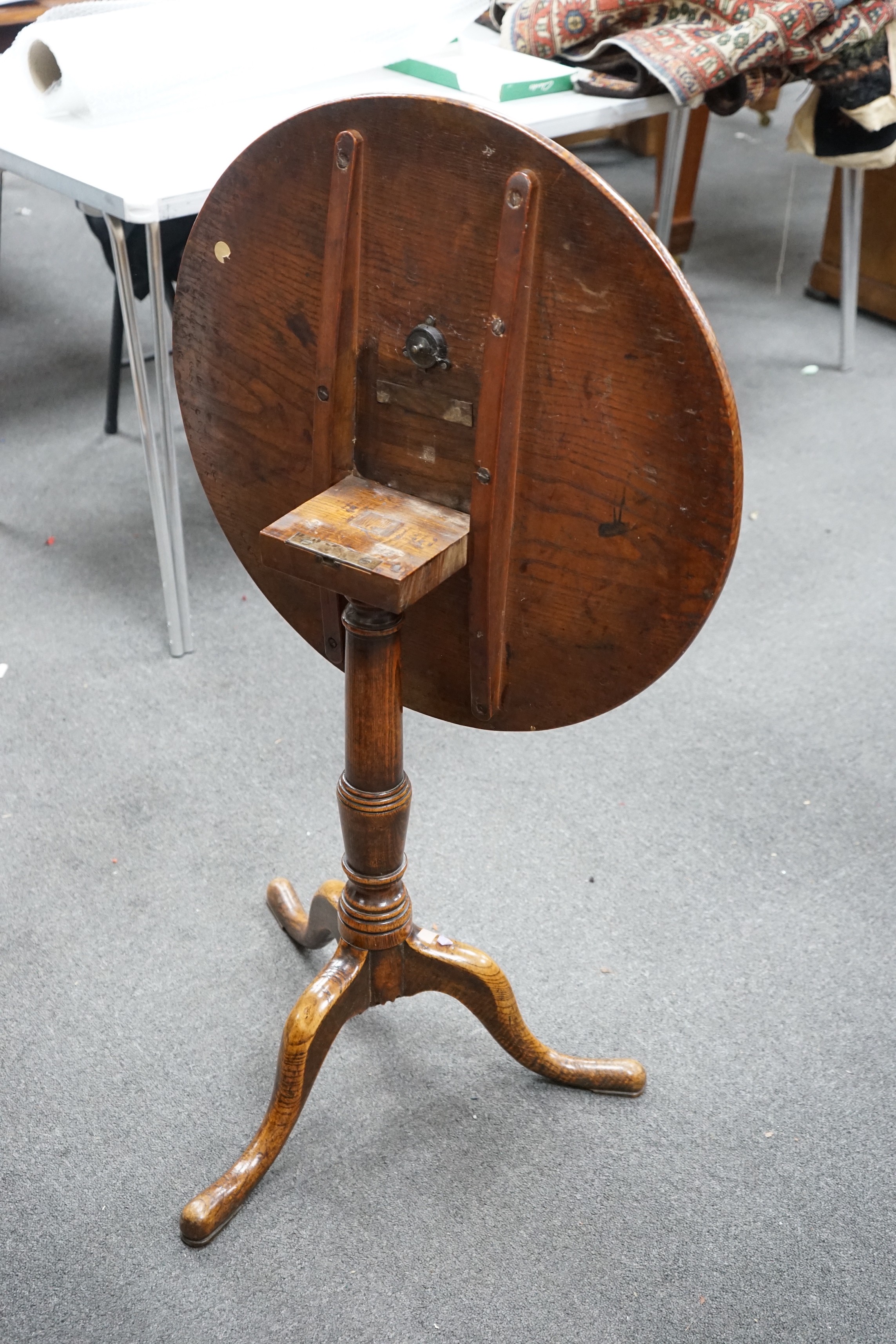 A George III circular oak tripod tilt top tea table on turned column, diameter 58cm, height 67cm